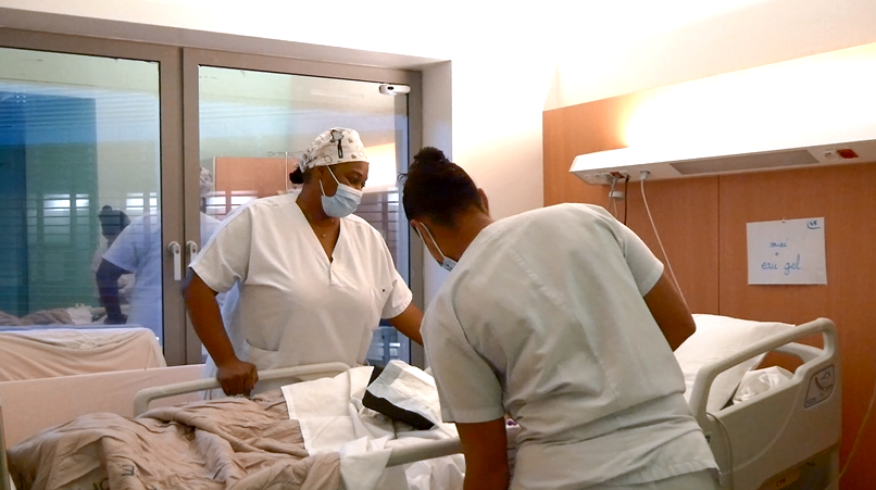 deux infirmières qui s'occupe d'une patiente hospitalisée pour maladies infectieuses 